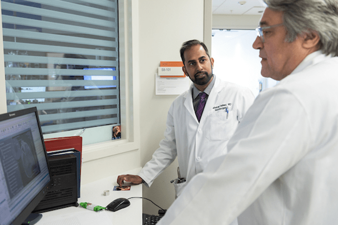 Doctors talking to each other and looking at a computer screen