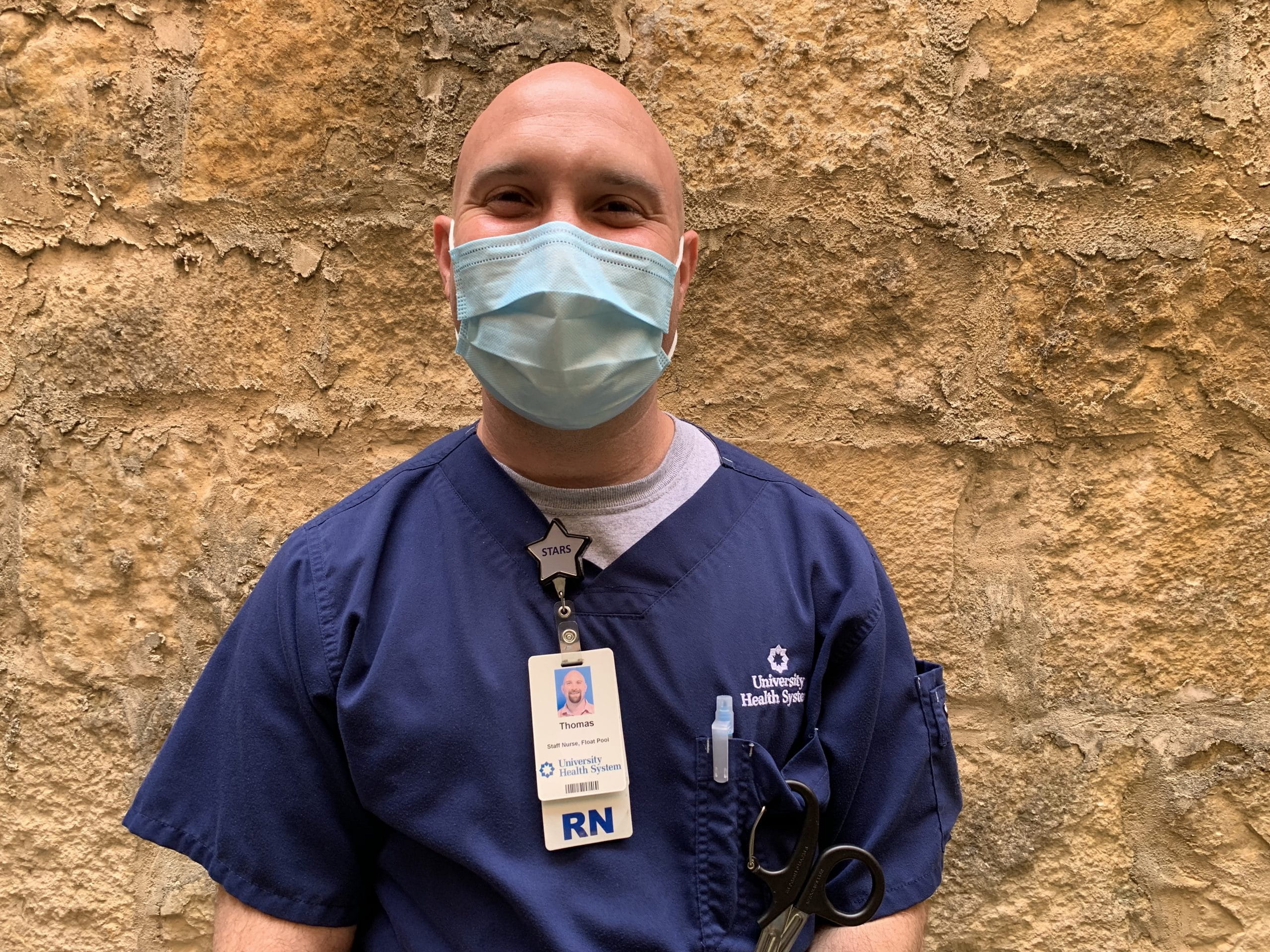 male healthcare worker wears a mask" width