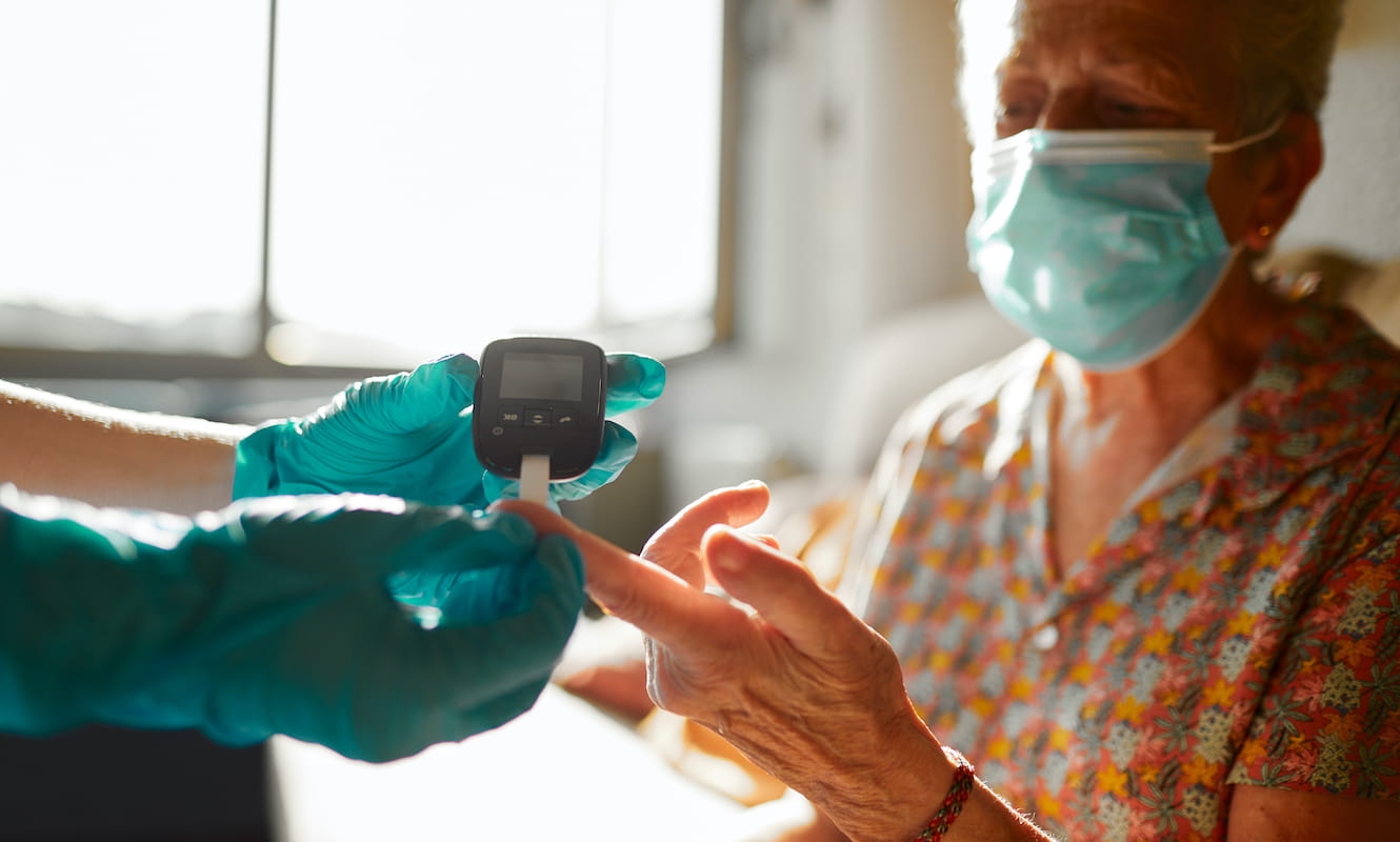 nurse performing a diabetes test on a senior person
