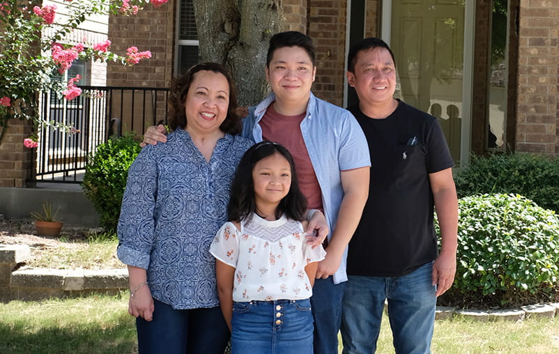 Monica and her family together in front of their home