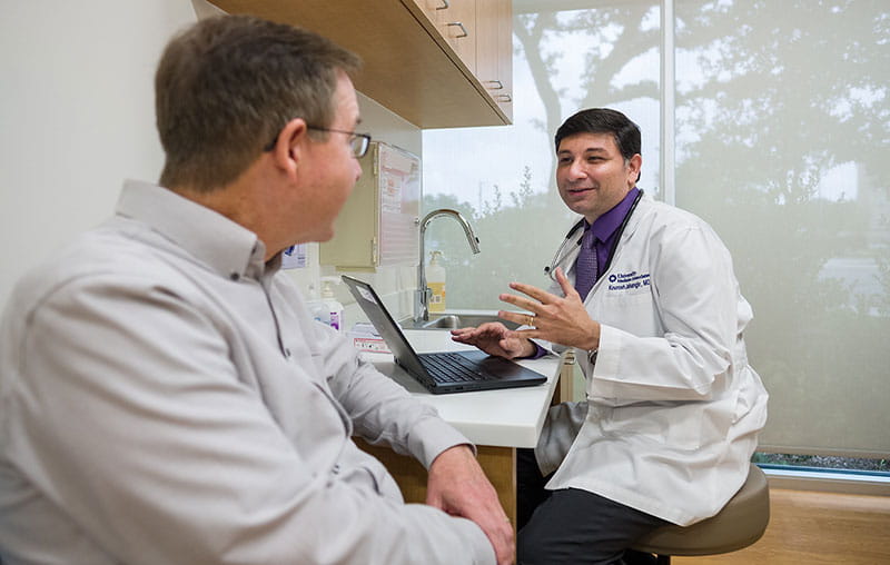 University Health family medicine provider, Dr. Kourosh Jahangir, speaking with male patient. 