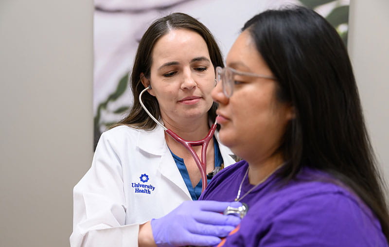 University Health nurse practitioner, Bobby Nguyen, examines female heart patient.
