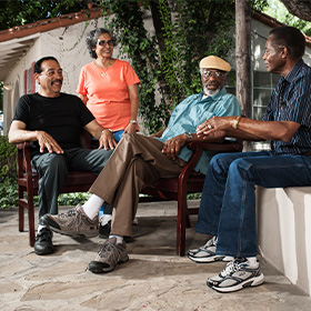 Four seniors hang out and chat outside.