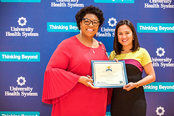 Tommye Austin, Senior Vice President of Nursing and Chief Nurse Executive, presents an award to a University Health nurse.