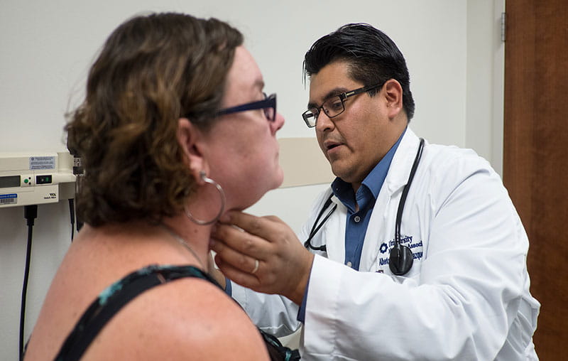 University Health endocrinologist, Alberto Chavez Velazquez, conducting physical exam on female patient.