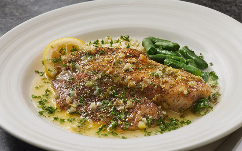 Baked tilapia plated with asparagus 